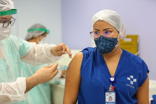 Trabalhadora da Saúde recebendo vacina contra a Covid-19. Reprodução: Internet.