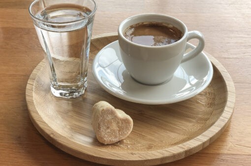 Turkish coffee and a glass of water served with a cookie